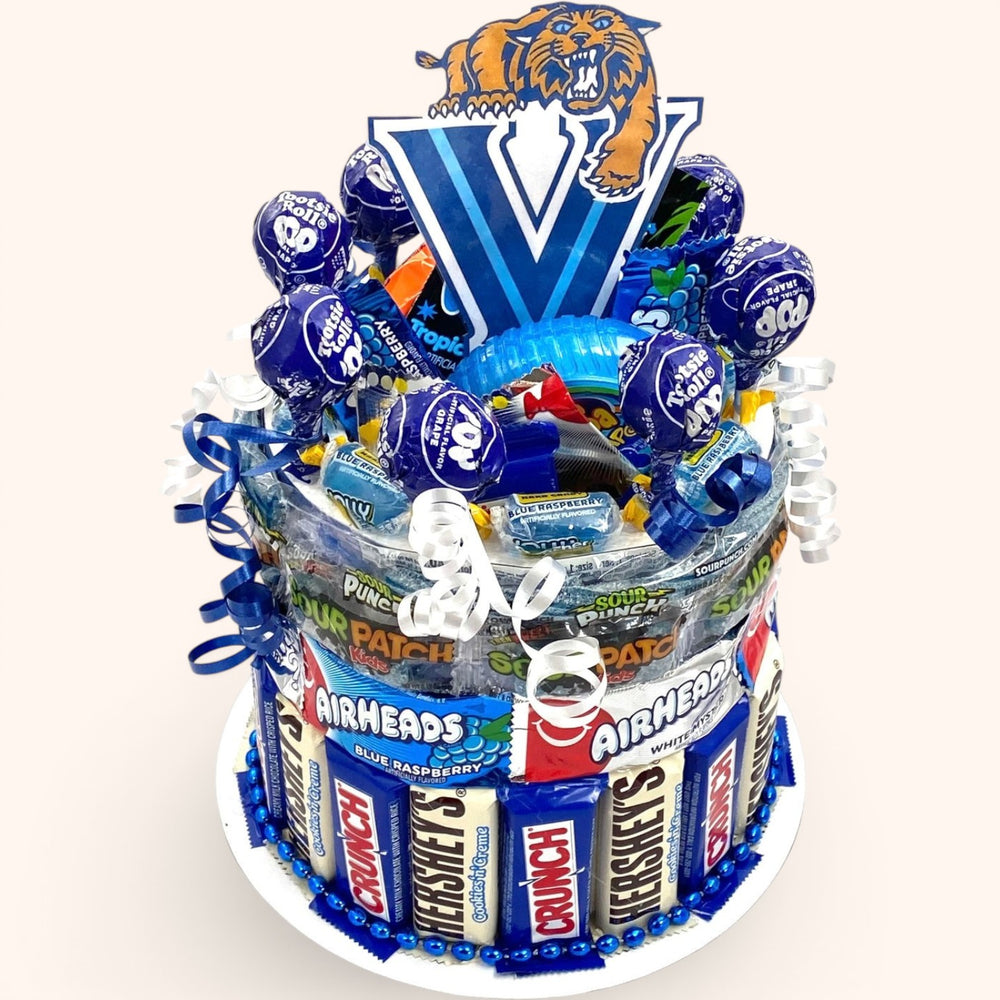 CandyCakeExplosion blue college candy cake featuring assorted chocolates, Airheads, and lollipops with mascot topper.