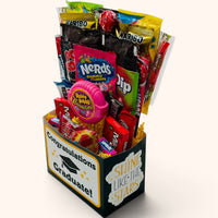 CandyCakeExplosion Congrats Graduate bouquet featuring assorted candy bars, chocolates, and sweets in a gift box.