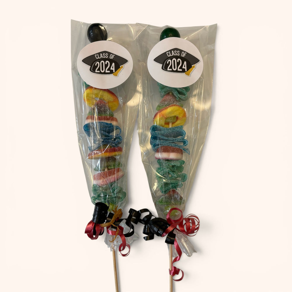 CandyCakeExplosion graduation candy kabobs with colorful gummies and Class of stickers in clear packaging.