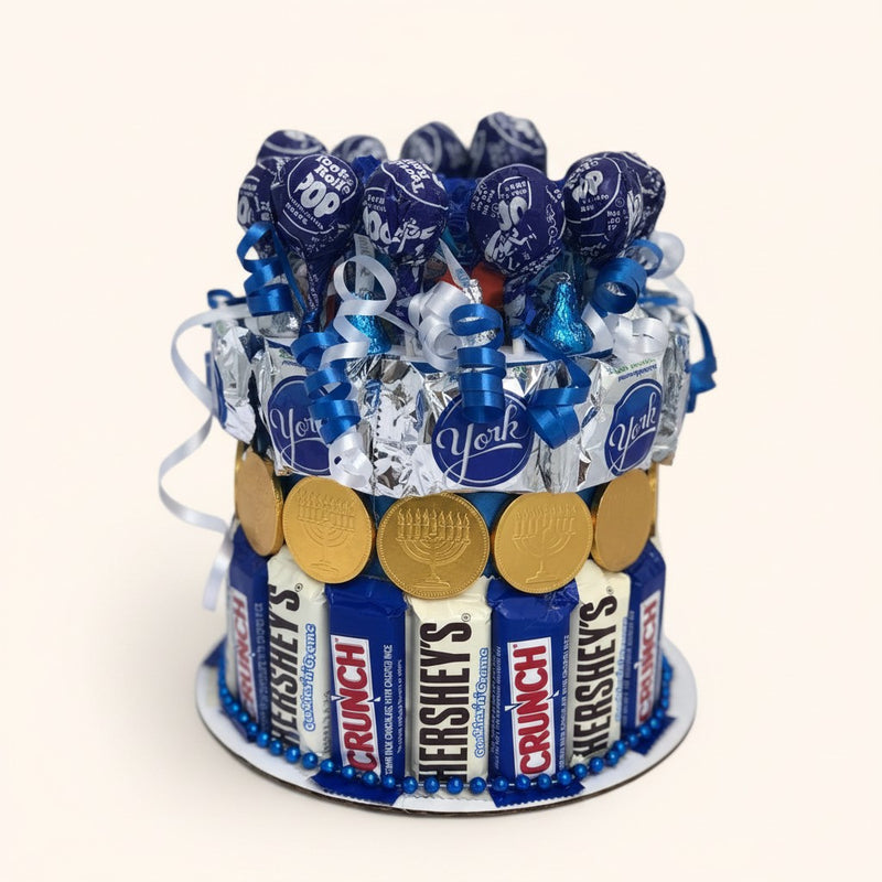 CandyCakeExplosion small Hanukkah candy cake decorated with blue lollipops, chocolate bars, and gold gelt coins.