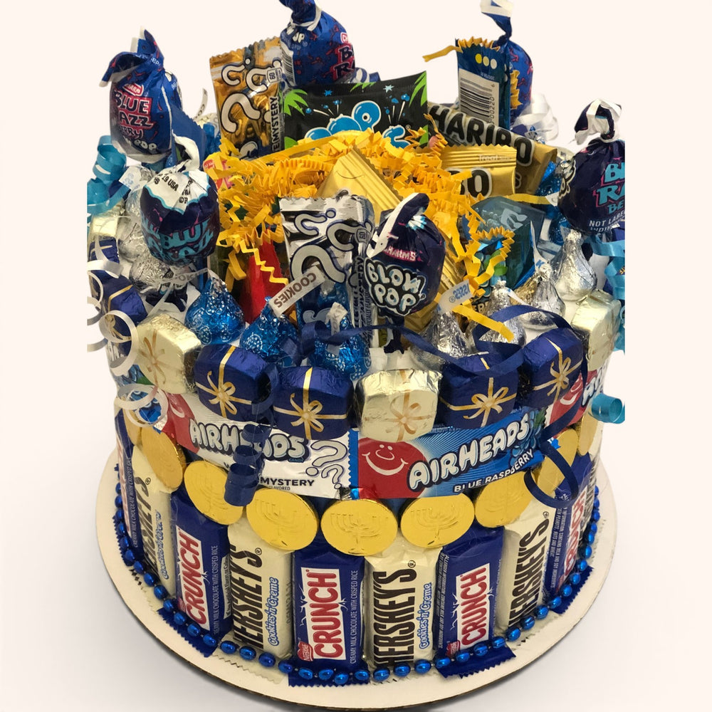CandyCakeExplosion medium Hanukkah candy cake featuring blue and white chocolates, milk chocolate gelt, and candy bars.