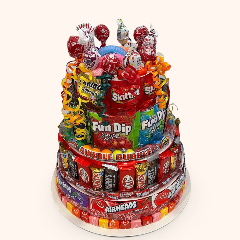 CandyCakeExplosion jumbo multi-tiered candy cake featuring assorted chocolate bars, lollipops, and fruity sweets.