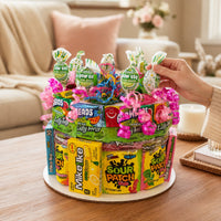 CandyCakeExplosion medium sour candy cake featuring Sour Patch Kids, Laffy Taffy, and Blow Pops with neon ribbons.