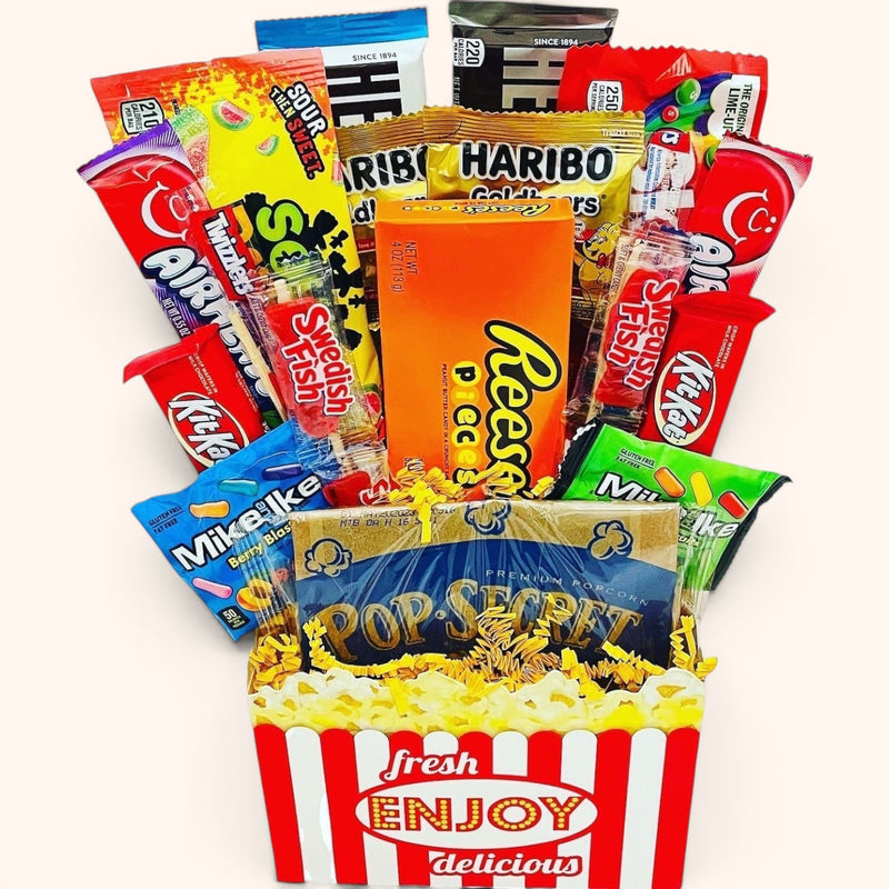 CandyCakeExplosion Movie Night Bouquet featuring assorted candy bars, chocolates, and popcorn in a striped bucket.