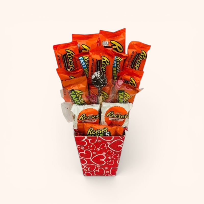 CandyCakeExplosion Peanut Butter Lovers Bouquet featuring assorted Reese's chocolate bars in a red heart-patterned container.