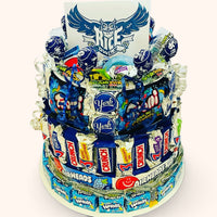 CandyCakeExplosion large multi-tiered candy cake featuring Rice Owls branding, assorted chocolate bars, and blue sweets.