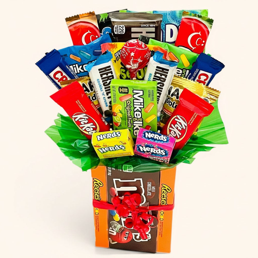 CandyCakeExplosion small candy bouquet featuring assorted chocolate bars and theater-sized candy boxes with a red bow.