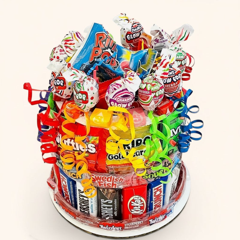 CandyCakeExplosion small candy cake decorated with assorted chocolate bars, lollipops, and colorful curling ribbons.