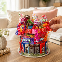 CandyCakeExplosion small yellow-themed candy cake featuring assorted chocolates and sweets with colorful ribbons.