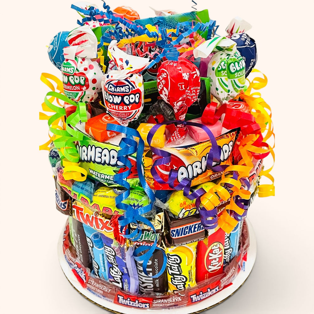 CandyCakeExplosion small tiered candy cake decorated with assorted chocolate bars, lollipops, and colorful ribbons.