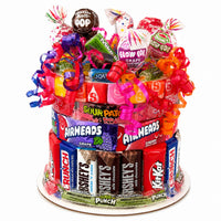 CandyCakeExplosion small candy cake featuring assorted chocolates, Airheads, and lollipops with bright curly ribbons.