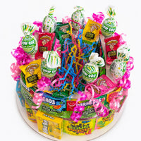 CandyCakeExplosion medium non-chocolate candy cake featuring sour belts, gummy rings, and lollipops with neon ribbons.