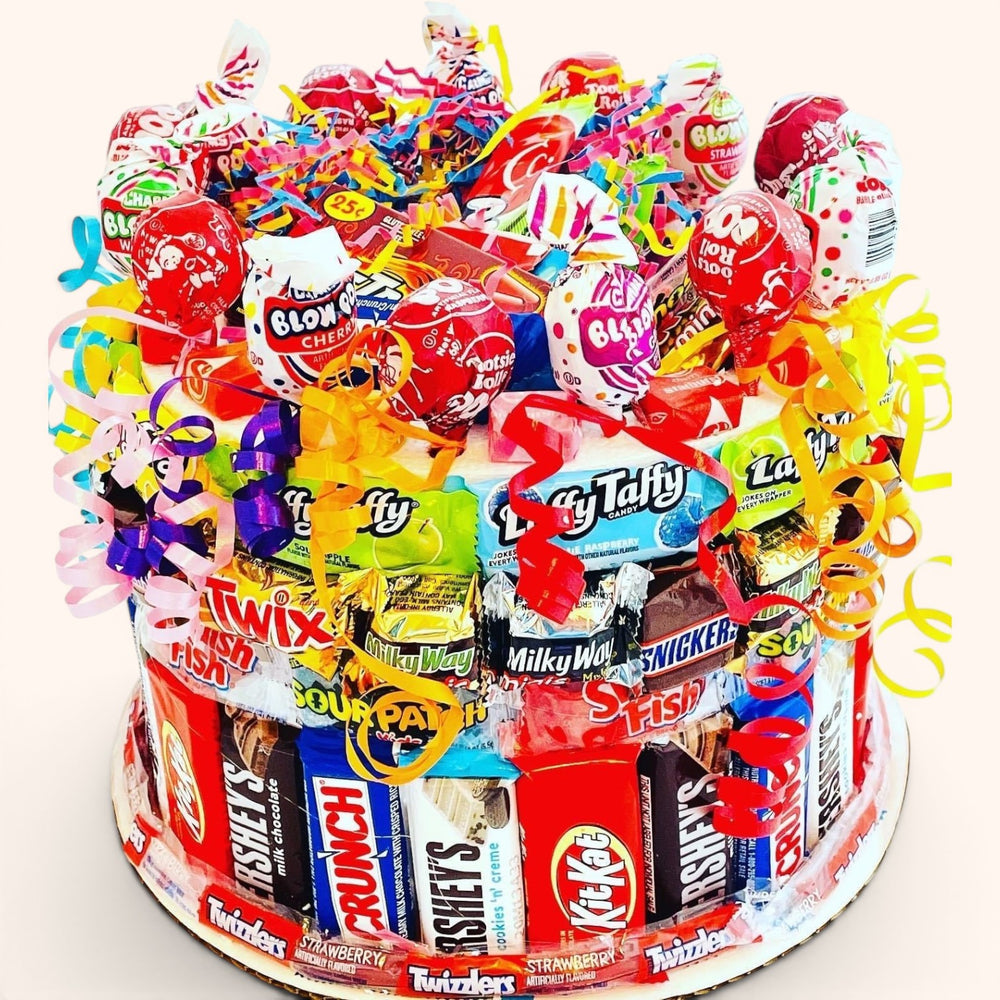 CandyCakeExplosion medium tiered candy cake featuring assorted chocolate bars, lollipops, and colorful ribbons.